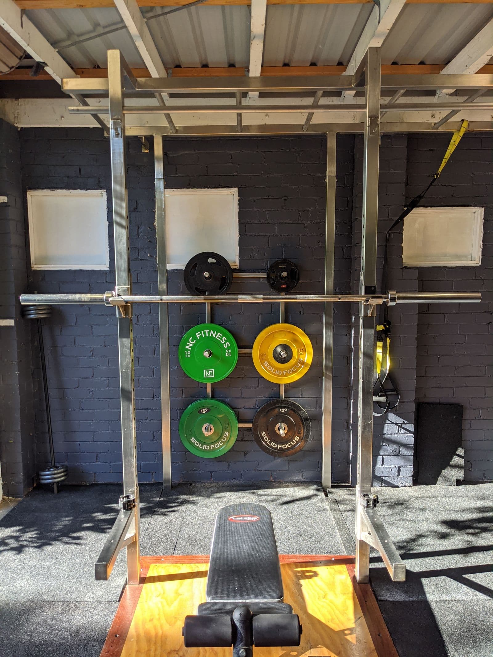 Weight plates and a barbell arranged on the gym floor