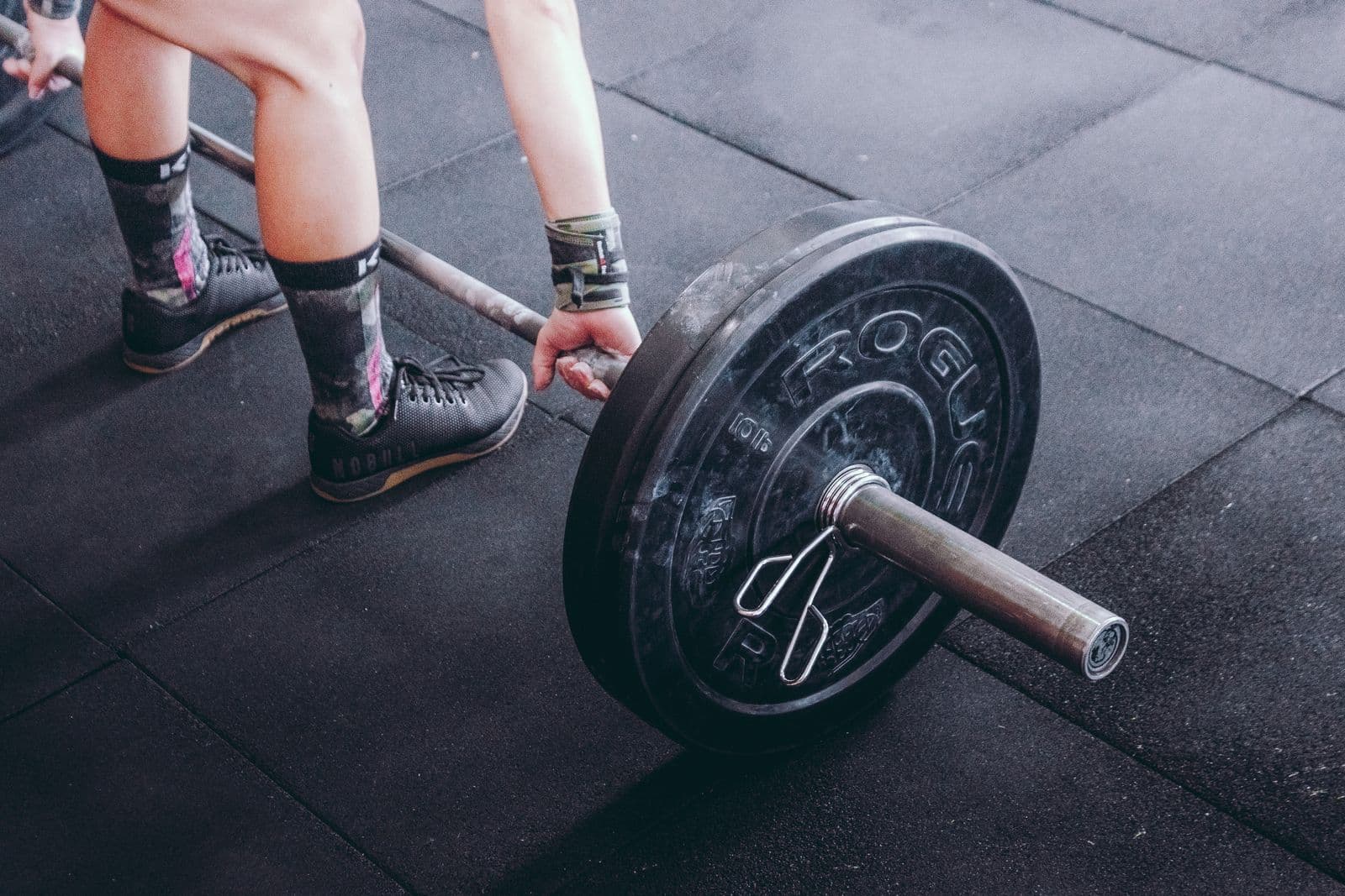 Hands on a black and grey loaded barbell